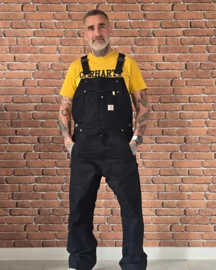 Homme en salopette noire et t-shirt jaune, de face