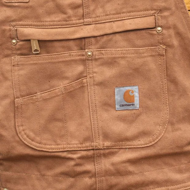 Bavette camel : poche zippée, poche stylo à l’entrée oblique et étiquette Carhartt