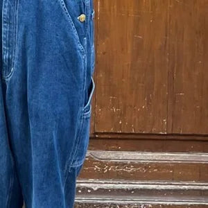 Côté de la jambe : poche verticale cousue et bouton de côté